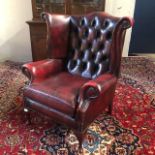 A WING BACK ARMCHAIR IN OXBLOOD LEATHER