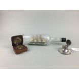 AN EARLY 20TH CENTURY SILVER INKWELL, A SHIP IN A BOTTLE AND A COMPASS