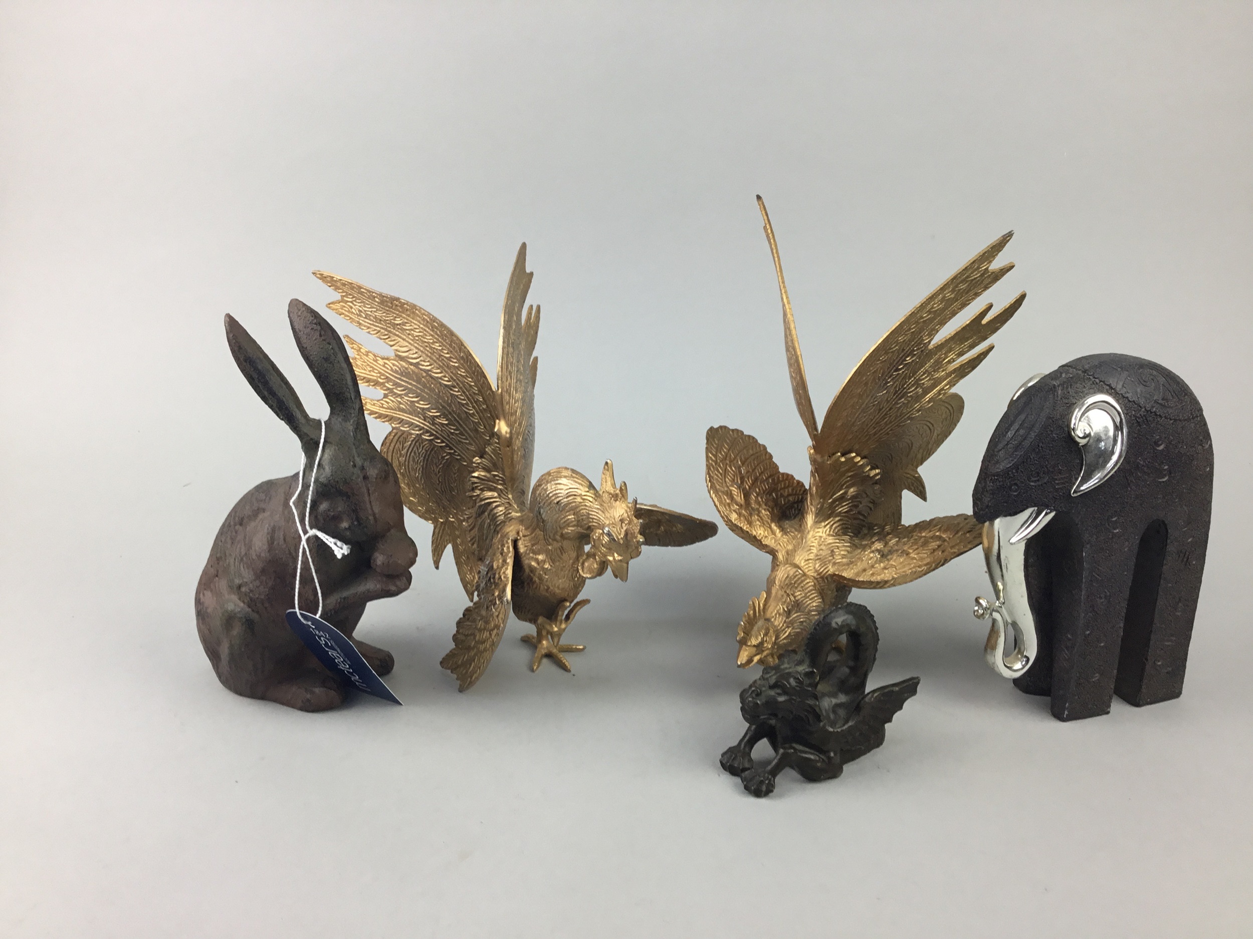 A PAIR OF CAST METAL FIGHTING COCKRELS ALONG WITH A RABBIT AN ELEPHANT AND A DRAGON