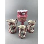 A SET OF THREE GRADUATED HAND PAINTED JUGS AND A PINK GLASS LUSTRE