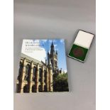 A GLASGOW UNIVERSITY 500 YEAR ANNIVERSARY MEDAL ALONG WITH A BOOK AND SCARF