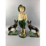 A PAINTED STUCCO FIGURE OF THE WHISTLING BOY ALONG WITH TWO ALSATIANS