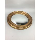 A GILT FRAMED CIRCULAR WALL MIRROR