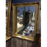 A GILT FRAMED WALL MIRROR