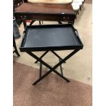 AN EBONISED BUTLERS TRAY ON FOLDING STAND