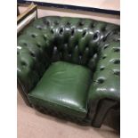 A GREEN LEATHER BUTTON BACK ARMCHAIR