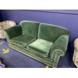 A GREEN UPHOLSTERED THREE SEATER SETTEE