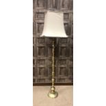 A BRASS STANDARD LAMP WITH CREAM SHADE