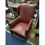AN EARLY 20TH CENTURY LEATHER ARMCHAIR AND A NEST OF THREE TABLES