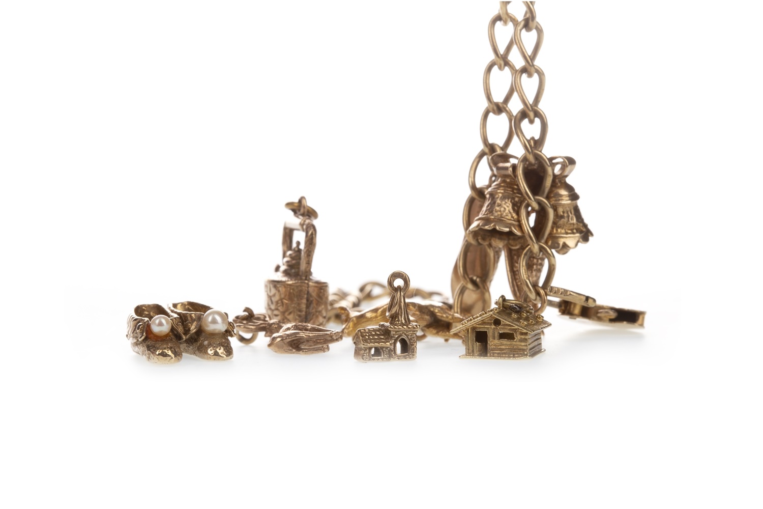 A GOLD CHARM BRACELET ALONG WITH LOOSE CHARMS