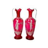 A PAIR OF VICTORIAN 'MARY GREGORY' STYLE CRANBERRY GLASS EWERS