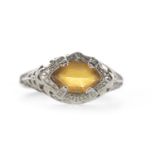 AN ORANGE GEM SET RING