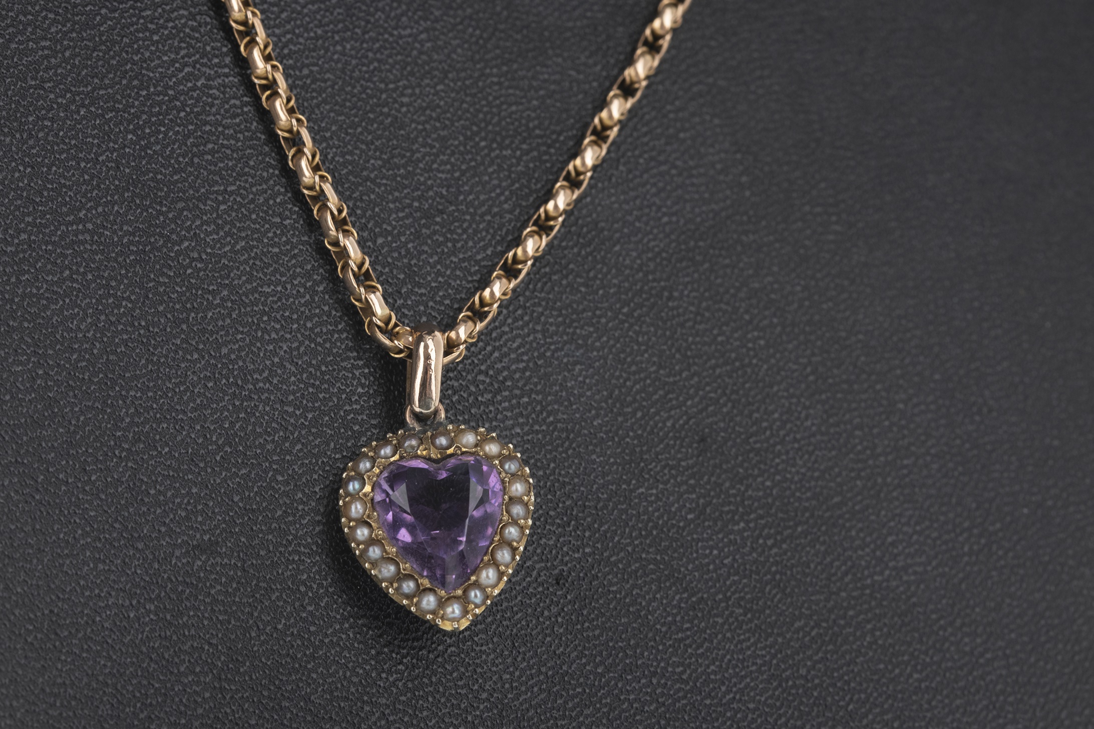 A PURPLE GEM SET AND SEED PEARL PENDANT ON CHAIN