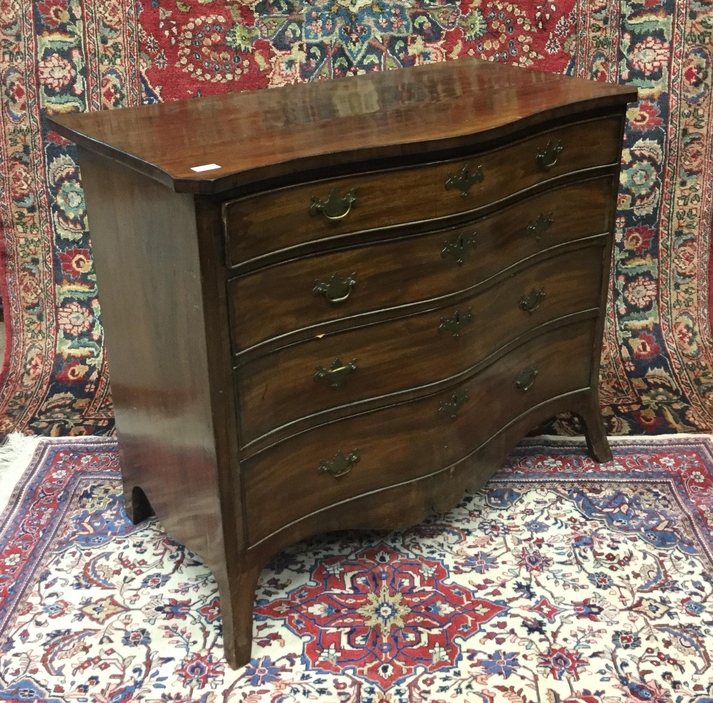 A MAHOGANY SERPENTINE CHEST OF DRAWERS
