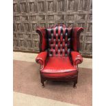 AN OXBLOOD LEATHER WINGBACK ARMCHAIR