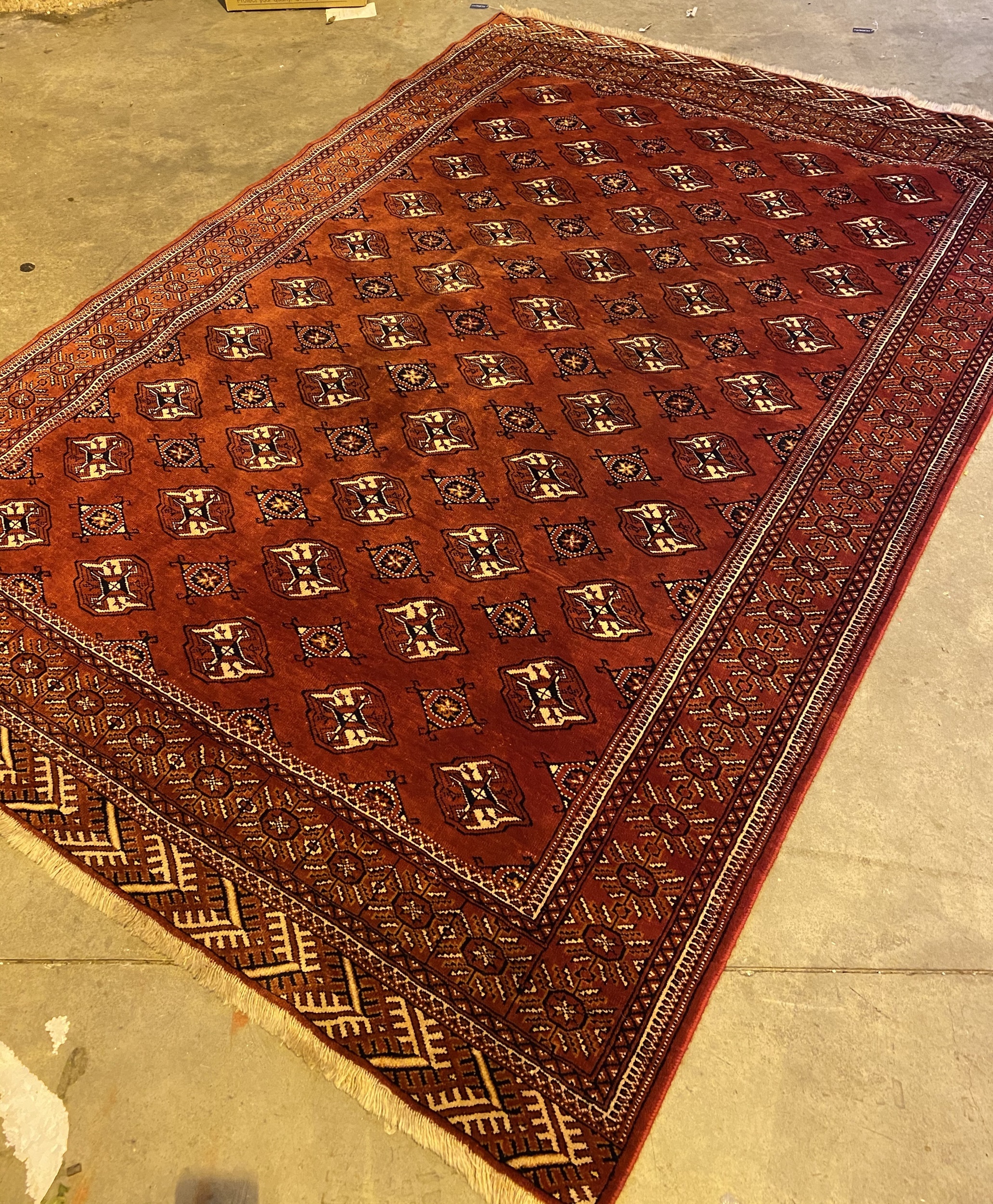 AN AFGHAN BOKHARA BORDERED CARPET