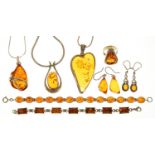 A QUANTITY OF AMBER JEWELLERY IN SILVER COMPRISING THREE PENDANTS, TWO BRACELETS, TWO PAIRS OF