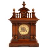 A 19TH C STAINED WOOD ARCHITECTURAL CASED MANTEL CLOCK WITH ARCHED PEDIMENT AND TURNED FINIALS, 47CM