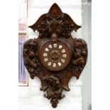 A BLACK FOREST CARVED WOOD WALL CLOCK, THE DIAL WITH ENAMEL CHAPTERS, 85CM H X 55CM W