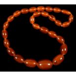 A NECKLACE OF AMBER COLOURED RESIN BEADS