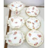 A COALPORT COMPOSED DESSERT SERVICE, EACH PIECE OF LIGHTLY MOULDED SCROLLING OUTLINE, PRINTED AND