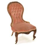 A VICTORIAN CARVED WALNUT NURSING CHAIR, UPHOLSTERED IN BUTTONED FABRIC