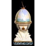 A ROYAL WORCESTER PORCELAIN AND GILTMETAL MOUNTED OCEAN RACING EGG BY KENNETH FOX, COMPRISING MODEL,