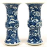 A PAIR OF CHINESE BLUE AND WHITE CYLINDRICAL VASES PAINTED WITH PRUNUS ON A CRACKED ICE GROUND, 19.