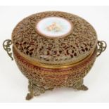 A VICTORIAN GILT BRASS FILIGREE ENCASED CRANBERRY GLASS BOWL AND COVER, THE COVER INSET WITH A WHITE