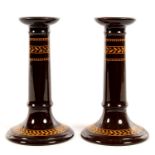 A PAIR OF WEDGWOOD BROWN GLAZED EARTHENWARE CANDLESTICKS WITH ACORN AND OAK LEAF OCHRE BANDED