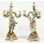 A PAIR OF SITZENDORF FLORAL ENCRUSTED CANDELABRA OF FOUR LIGHTS ON ROSE ENTWINED SCROLLING BRANCHES,