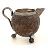 AN UNUSUAL VICTORIAN SILVER COLOURED METAL MOUNTED CARVED COCONUT MILK JUG, ON CLAW AND BALL FEET,