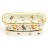 A CONTINENTAL PORCELAIN SARCOPHAGUS SHAPED PEN TRAY, PAINTED WITH BIRDS IN BRANCHES, ON PAW FEET AND