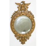 A VICTORIAN CAST IRON MIRROR IN REGENCY STYLE WITH BEVELLED ROUND PLATE AND CRESTED BY AN EAGLE,