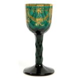 AN EMERALD GREEN GLASS WINE, THE FACETED BOWL GILT WITH SWAGS AND PENDANTS, ON FACET CUT STEM AND