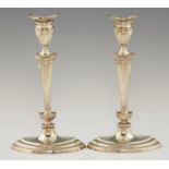 A PAIR OF EDWARD VII SILVER CANDLESTICKS  with tapered stem on moulded navette shaped foot, nozzles,