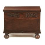 AN OAK CHEST, LATE 17TH C AND LATER  with boarded lid, the front carved with initials E.A.H. and