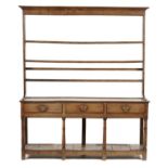 A GEORGE III OAK DRESSER, EARLY 19TH C the lofty rack with cavetto cornice and three moulded