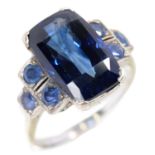 A SAPPHIRE RING, C1925 with stepped shoulders, the principal sapphire 8.6ct approx, in white metal,