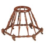 A VICTORIAN STAINED BEECH BABY WALKER  of spindle construction and hexagonal form, iron castors,