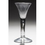 AN ENGLISH WINE GLASS, C 1750  the drawn trumpet bowl on solid stem with tear, conical foot, 16cm