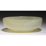 A CHINESE JADE BOWL, POSSIBLY 19TH C on circular foot, 12cm diam and a wood stand Bowl in good