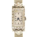AN ART DECO COCKTAIL WATCH in 18ct white gold, 22 X 14 mm, on 9ct white gold mail bracelet,