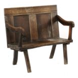 A JOINED OAK SETTLE  the twin panel back, channel frame and having shaped arms, blank seat, 91cm