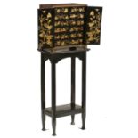 A CHINESE EXPORT LACQUER TABLE CABINET, EARLY 19TH C  decorated with temple scenes and island in
