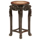 A CHINESE CARVED HONGMU STAND, C1900 with stone inset top, 61cm h, 34cm diam Good condition with