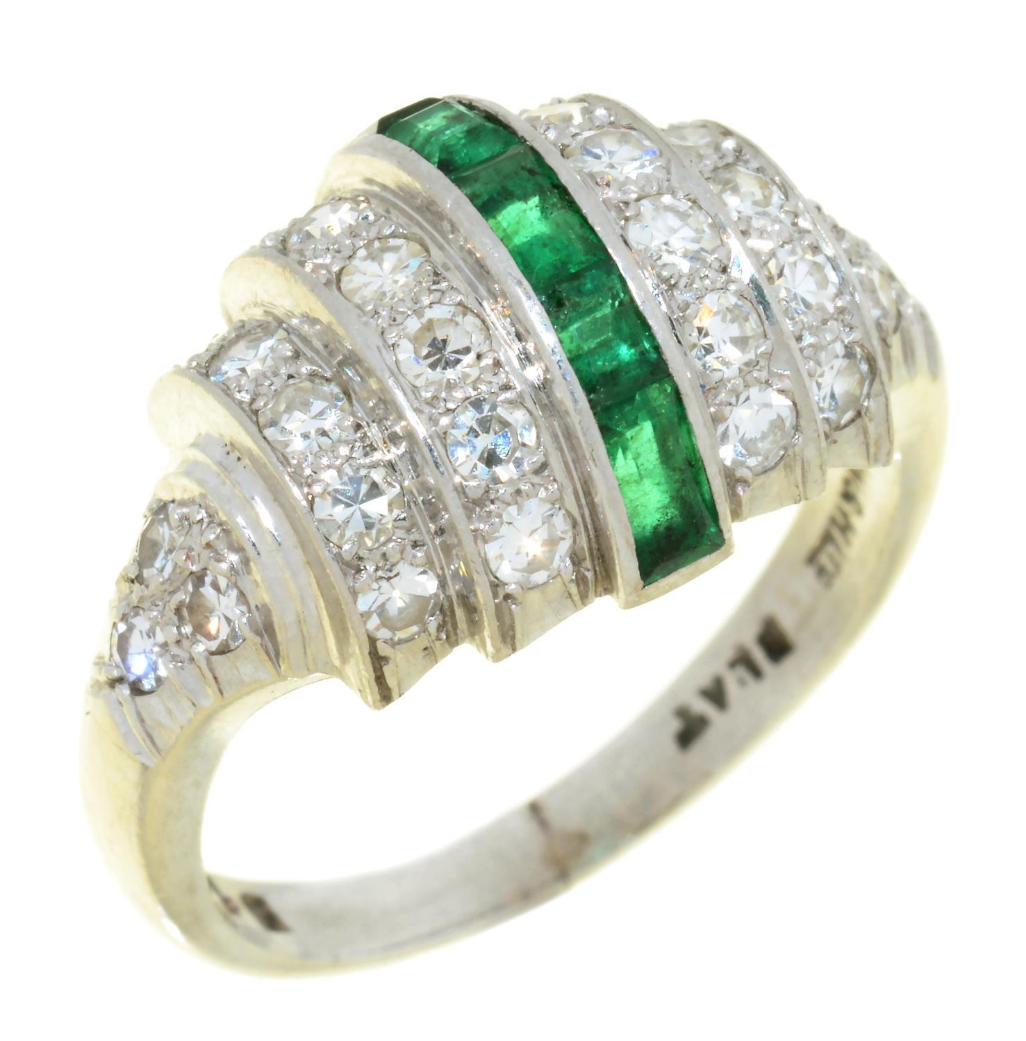 AN ART DECO EMERALD AND DIAMOND COCKTAIL RING with central line of calibre cut emeralds, in