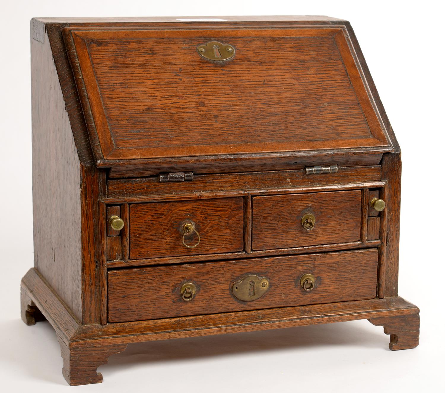 MINIATURE FURNITURE.  A GEORGE III STYLE OAK AND CROSSBANDED BUREAU, 25CM  H.