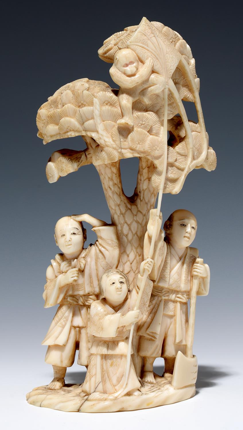 A JAPANESE IVORY OKIMONO OF A WOODCUTTER AND TWO FIGURES WITH A TETHERED MONKEY ABOVE IN THE CROWN