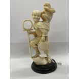 A JAPANESE IVORY OKIMONO OF A MONKEY TRAINER. 13.5CM H, MEIJI PERIOD, AFFIXED WOOD BASE